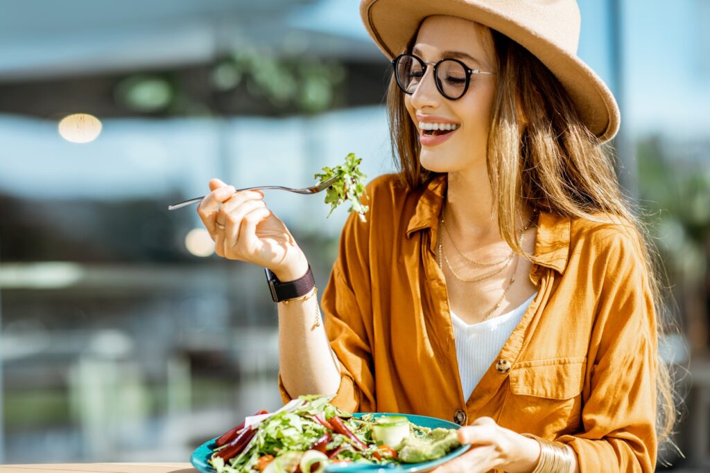 Woman eating salad on a cafe terrace